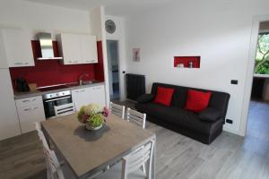 a kitchen and a living room with a table and a couch at Villa Lori Apartments Garden and Beach in Peschiera del Garda