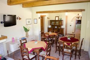 a dining room with tables and chairs and a tv at Agriturismo Pompagnano in Pompagnano