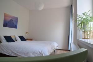 een slaapkamer met een bed en een groene stoel bij Vintage-Ferienwohnung für 2 in Schörfling