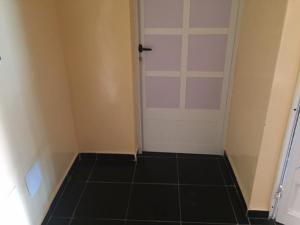 um quarto com uma porta e piso em azulejo em MINI VILLA ROSE em Lomé