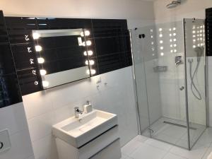 a white bathroom with a sink and a shower at Apartament TOP Pięć Mórz basen&SPA in Sianozety +12 photos