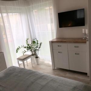 a bedroom with a dresser with a flat screen tv at Apartament TOP Pięć Mórz basen&SPA in Sianozety