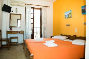 a bedroom with two beds and a desk and a mirror at Eleni's House Skiathos in Skiathos