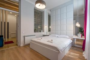 ein weißes Schlafzimmer mit einem großen Bett und einem Fenster in der Unterkunft Irina's cozy apartment #21 in Tbilisi City