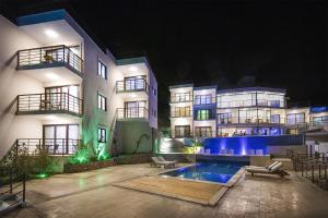 a large apartment building with a swimming pool at night at Highclere Hotel and Spa in Faralya