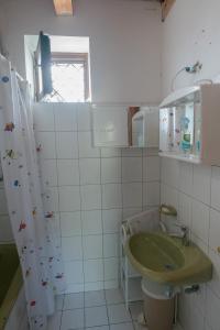 a bathroom with a green sink and a window at Hillside Vendégház a Szent György-hegyen in Raposka