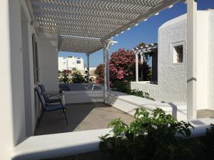 a patio with a chair under a pergola at Diogenis Village Mykonos in Glastros