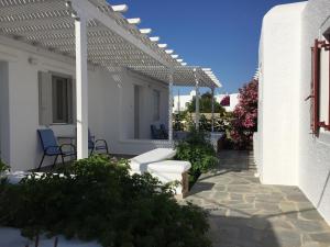 une terrasse blanche avec pergola sur une maison blanche dans l'établissement Diogenis Village Mykonos, à Glastros