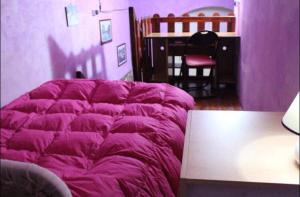シラクーサにあるRiviera house holidayの紫色のベッドルーム(ベッド1台、テーブル付)