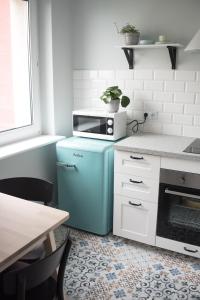 een keuken met een blauwe koelkast en een magnetron bij TS Budget Stay in Szczecin