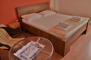 um pequeno quarto com uma cama com uma mesa e copos em Villa Galeb Pag - at the main Beach em Pag