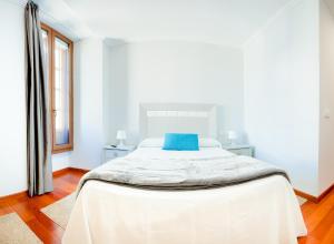 A bed or beds in a room at Apartamentos Villa Zoila Baiona