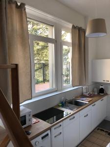 a kitchen with a sink and two windows at Apartment Italy in Interlaken