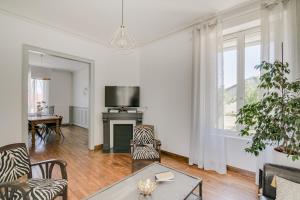 a living room with a table and a tv at Maison Qui s'y frotte s'y pique in Robert-Espagne