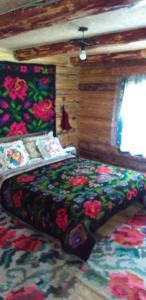 a bedroom with a bed with a colorful bedspread at Pensiunea Anita in Vişeu de Sus