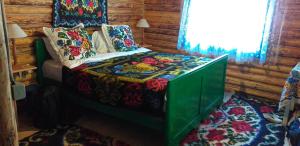 ein Schlafzimmer mit einem Bett in einem Blockhaus in der Unterkunft Pensiunea Anita in Vişeu de Sus
