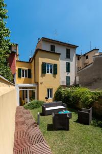 een tuin met een huis op de achtergrond bij SCALA GARDEN Apartment in Florence