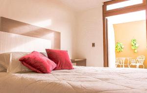 Un dormitorio con una cama con almohadas rojas. en Hotel Boutique Suri, en La Serena