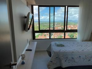 Zimmer mit einem Bett und einem großen Fenster in der Unterkunft Flat novo no Complexo Heron Marinho in Campina Grande