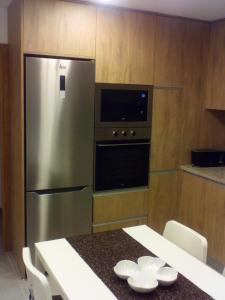 a kitchen with a stainless steel refrigerator and a table at Home Sleep Home Fafe in Fafe