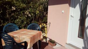 ein Tisch mit zwei blauen Stühlen und ein Tisch mit in der Unterkunft Sole 1 in Novigrad Istria