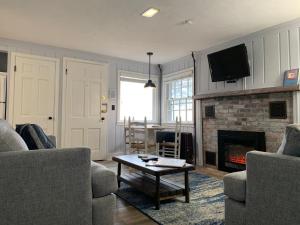 a living room with two couches and a fireplace at The Masthead Resort in Provincetown