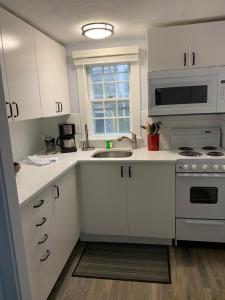 a kitchen with white cabinets and a sink at The Masthead Resort in Provincetown