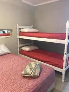 sypialnia z 2 łóżkami piętrowymi i czerwoną pościelą w obiekcie Casas aconchegantes w mieście São Sebastião