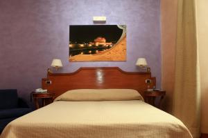 a bedroom with a bed and a painting on the wall at Hotel Kent in Rome