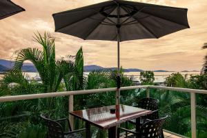 a patio area with a table and umbrella at Sunlit Waters Studio Apartments in Airlie Beach