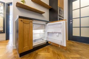 an open refrigerator in a kitchen with wood floors at LVIV -APART центр 2 кім ізольовані і кухня студія in Lviv