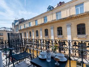 a table with plates and glasses on a balcony at LvApart вул Ковжуна 2 кім ізол кухня студія звітні документи in Lviv