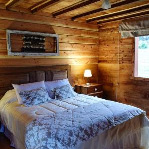 1 dormitorio con 1 cama en una habitación de madera en Lodge El Sarao A Una Hora De Puerto Varas, en Fresia