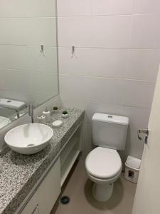 a bathroom with a white toilet and a sink at Flat Granja Viana in Cotia