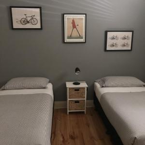 two beds in a room with three pictures on the wall at Lotte's Cottage in Broken Hill