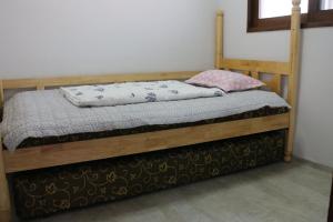 a bedroom with a wooden bed with pillows on it at DASAN HOUSE in Seoul