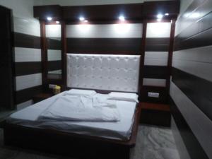 a small bed in a room with black and white stripes at Vidya Guest House in Katra