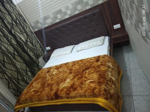 a bedroom with a bed with a brown and white comforter at Vidya Guest House in Katra