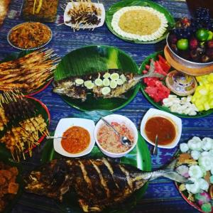 einen Tisch mit vielen verschiedenen Arten von Lebensmitteln in der Unterkunft Rinjani Beach Eco Resort in Tanjung