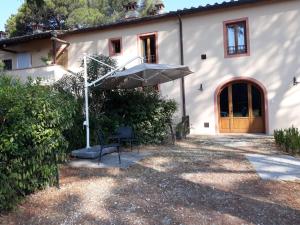 a house with a table and an umbrella at Villa Leonardo in Vinci