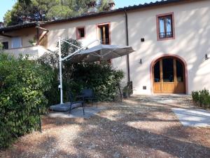 una casa con mesa y sombrilla en Villa Leonardo, en Vinci