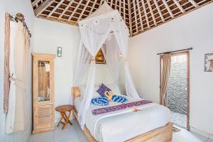 a bedroom with a bed with a mosquito net at Svaha Private Villas Ceningan in Nusa Lembongan
