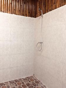 a shower with a shower head on a wall at Pantai Paris Homestay in Maumere