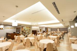 un comedor con mesas y sillas blancas en King's Resort & Spa en Taian