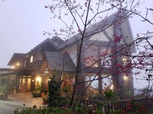 a house with a tree in front of it at Top Cloud Villa in Renai