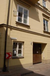 un edificio con una puerta, una ventana y una señal en Mieszkanie Old Town Apartment, en Vilna