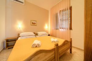 een slaapkamer met een bed met handdoeken erop bij Apartments Loncar in Krk