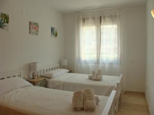 zwei Betten in einem Zimmer mit Handtüchern darauf in der Unterkunft Jardines de Montemar in Benissa + 27 Fotos