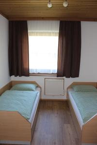 two beds in a room with a window at Apartment-Kraft in Lungötz