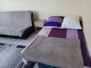 a small bedroom with a bed and a couch at Apartament u Basi in Gdańsk
